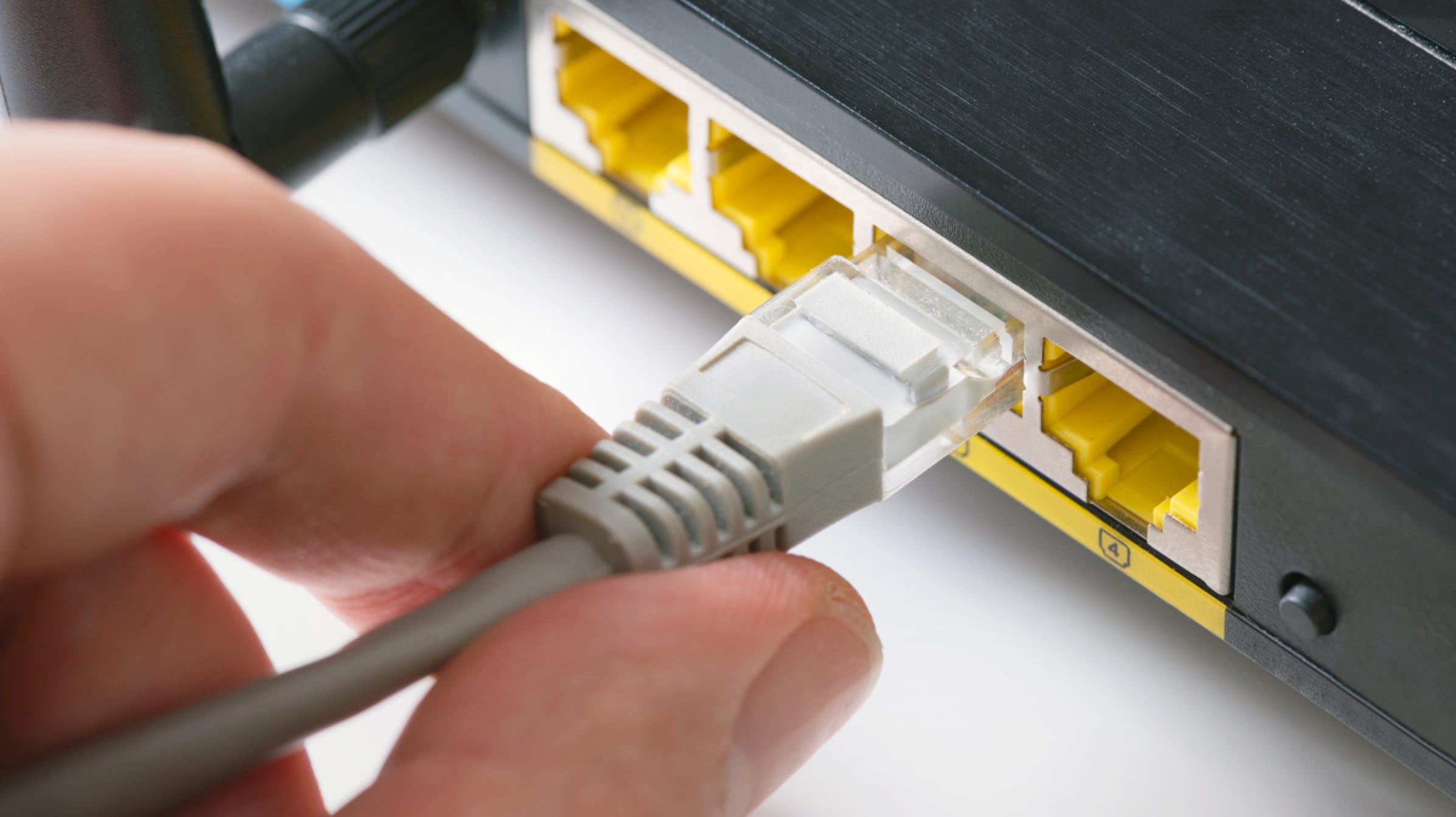 hand-inserting-ethernet-cable-router